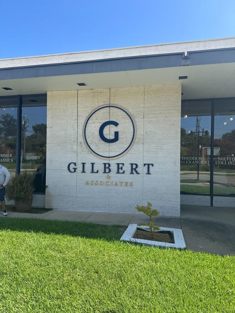 Gilbert G logo sign on the showroom's limestone entry wall