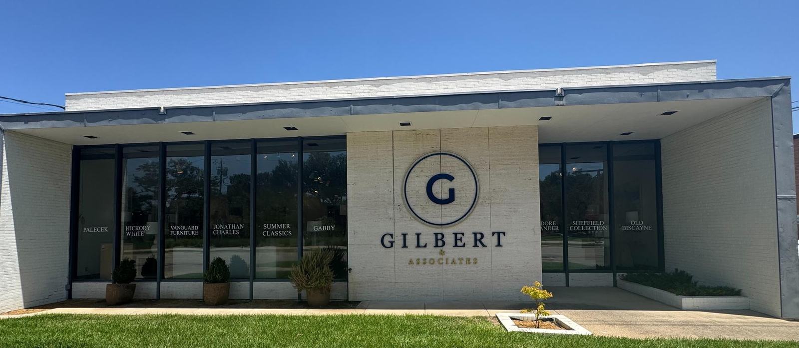 Front of the David Gilbert & Associates showroom building with the Gilbert G logo on a limestone wall