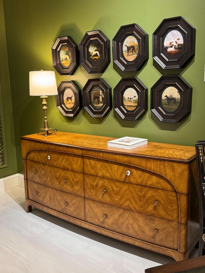 Burl dresser beneath a wall of octagonal framed prints in a green-walled vignette