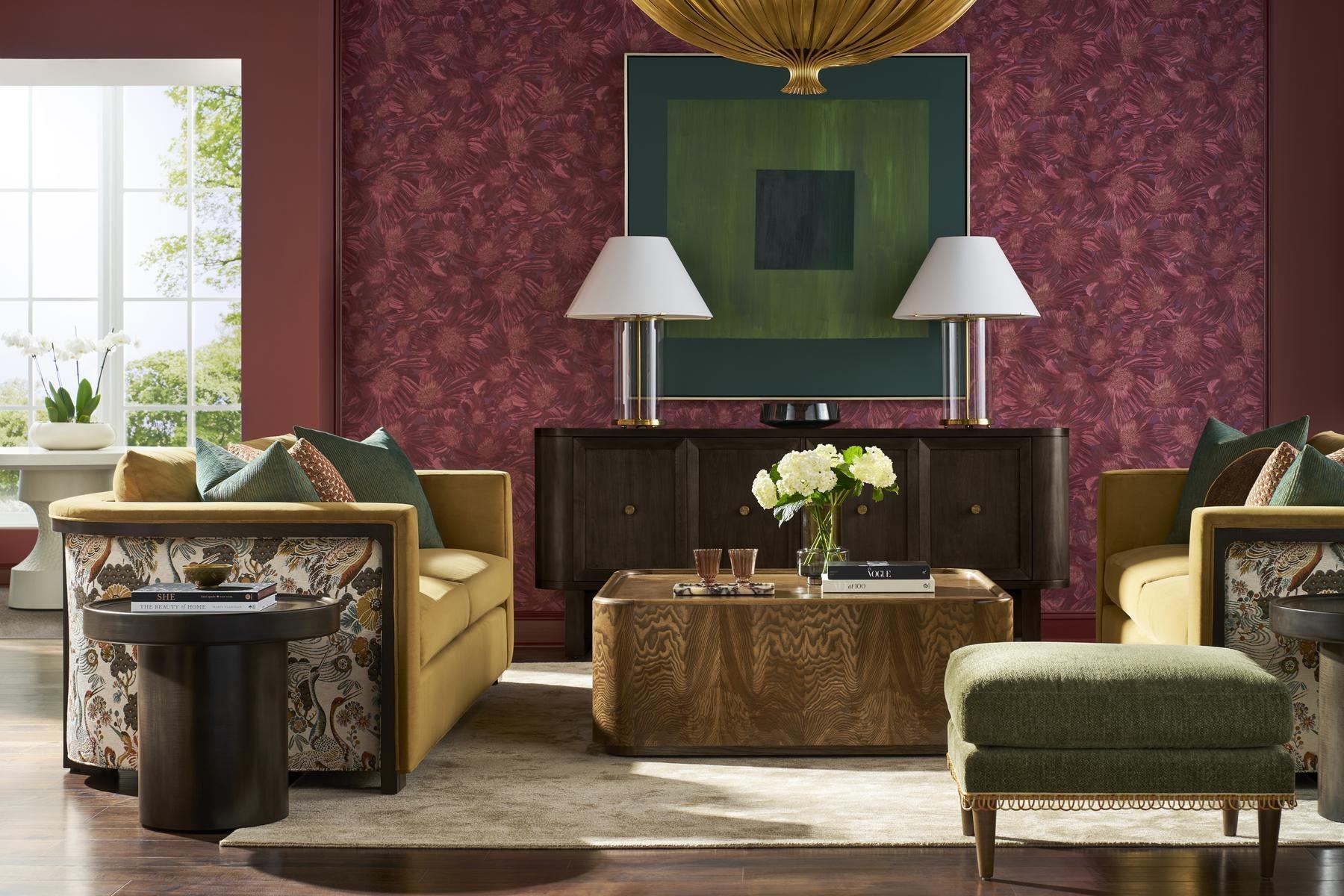 Living room with a curved gold sofa, burl cocktail table and red patterned walls